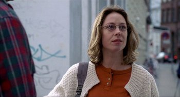 Movie still from “The One and Only” (1999), directed by Susanne Bier – A woman wearing glasses and an orange shirt is walking; Close Up shot, Low angle