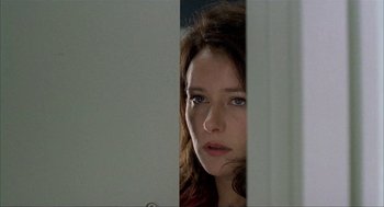 Movie still from “The One and Only” (1999), directed by Susanne Bier – A woman's face as she peeks out from behind a wall; Close Up shot, Over the shoulder angle