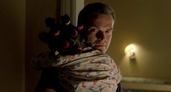 Movie still from “The One and Only” (1999), directed by Susanne Bier – A man holding a stuffed animal wrapped around his back; Close Up shot, Over the shoulder angle