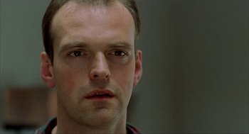 Movie still from “The One and Only” (1999), directed by Susanne Bier – A man's face in a dark room; Close Up shot, Low angle