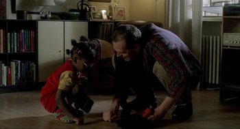 Movie still from “The One and Only” (1999), directed by Susanne Bier – A man and a little girl are playing with a toy; Medium shot, High angle