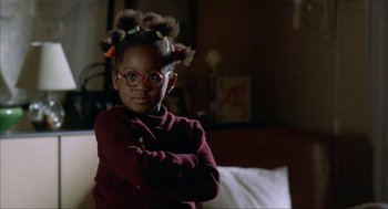 Movie still from “The One and Only” (1999), directed by Susanne Bier – A little girl wearing glasses and holding her arms crossed; Close Up shot, Low angle