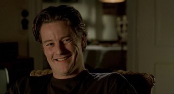 Movie still from “The One and Only” (1999), directed by Susanne Bier – A person sitting in a chair smiling; Close Up shot, Low angle