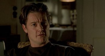 Movie still from “The One and Only” (1999), directed by Susanne Bier – A person sitting in a chair looking at the camera; Close Up shot, Over the shoulder angle