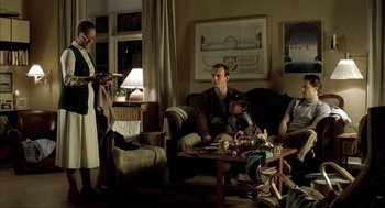 Movie still from “The One and Only” (1999), directed by Susanne Bier – A group of people sitting around a living room; Medium shot, Over the shoulder angle