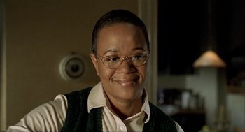 Movie still from “The One and Only” (1999), directed by Susanne Bier – A woman wearing glasses and a sweater vest; Close Up shot, Low angle