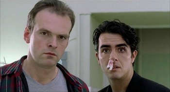 Movie still from “The One and Only” (1999), directed by Susanne Bier – Two men standing next to each other in front of a wall; Close Up shot, Low angle
