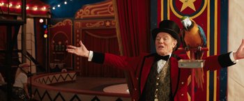 Movie still from “The One and Only Ivan” (2020), directed by Thea Sharrock – An older man in a top hat and a red jacket; Medium shot, Low angle