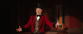 Movie still from “The One and Only Ivan” (2020), directed by Thea Sharrock – A man in a red jacket and a top hat; Medium shot, Low angle