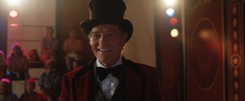 Movie still from “The One and Only Ivan” (2020), directed by Thea Sharrock – An older man wearing a top hat and a red jacket; Close Up shot, Over the shoulder angle