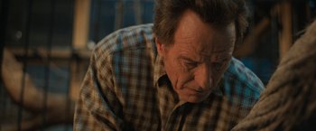 Movie still from “The One and Only Ivan” (2020), directed by Thea Sharrock – An older man in a brown and white plaid shirt; Close Up shot, High angle