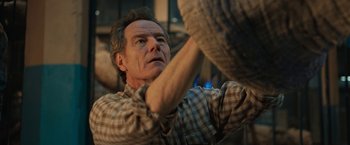 Movie still from “The One and Only Ivan” (2020), directed by Thea Sharrock – An older man is holding something in his hand; Close Up shot, Low angle