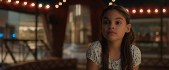 Movie still from “The One and Only Ivan” (2020), directed by Thea Sharrock – A young girl sitting in front of a building; Close Up shot, Over the shoulder angle