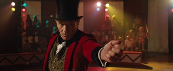 Movie still from “The One and Only Ivan” (2020), directed by Thea Sharrock – A man in a top hat and a red jacket holding his hand out; Close Up shot, Low angle