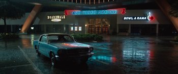 Movie still from “The One and Only Ivan” (2020), directed by Thea Sharrock – A car parked in front of an arcade at night; Extreme Wide shot, High angle