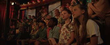 Movie still from “The One and Only Ivan” (2020), directed by Thea Sharrock – A group of people sitting in a row watching a show; Medium shot, Low angle