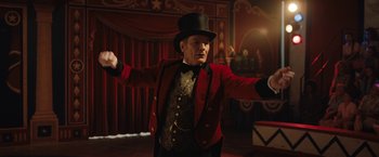 Movie still from “The One and Only Ivan” (2020), directed by Thea Sharrock – A man wearing a top hat and a red jacket; Medium shot, Low angle