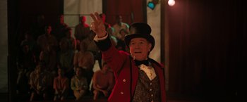 Movie still from “The One and Only Ivan” (2020), directed by Thea Sharrock – An older man in a top hat and a red jacket; Medium shot, Low angle
