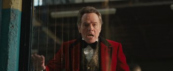 Movie still from “The One and Only Ivan” (2020), directed by Thea Sharrock – An older man wearing a red jacket and a black bow tie; Close Up shot, Low angle