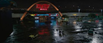 Movie still from “The One and Only Ivan” (2020), directed by Thea Sharrock – People are walking in the rain in front of a mall; Extreme Wide shot, High angle