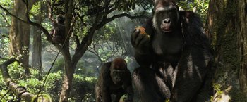 Movie still from “The One and Only Ivan” (2020), directed by Thea Sharrock – A gorilla and her baby eating fruit in a forest; Wide shot, Low angle