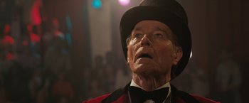 Movie still from “The One and Only Ivan” (2020), directed by Thea Sharrock – An old man wearing a red jacket and a black hat; Close Up shot, Low angle