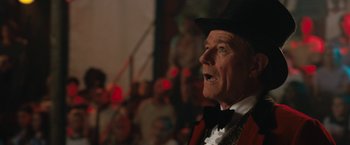 Movie still from “The One and Only Ivan” (2020), directed by Thea Sharrock – An older man wearing a top hat and a bow tie; Close Up shot, Low angle