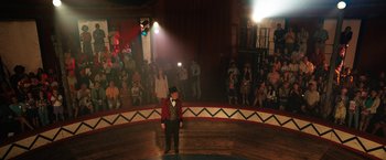 Movie still from “The One and Only Ivan” (2020), directed by Thea Sharrock – A man standing on a stage in front of an audience; Extreme Wide shot, High angle