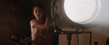 Movie still from “The One and Only Ivan” (2020), directed by Thea Sharrock – A young girl standing in front of a light; Medium shot, Low angle
