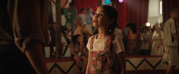 Movie still from “The One and Only Ivan” (2020), directed by Thea Sharrock – A little girl standing in front of a group of people; Close Up shot, Over the shoulder angle
