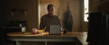 Movie still from “The One and Only Ivan” (2020), directed by Thea Sharrock – An older man sitting in front of a laptop computer; Medium shot, Low angle