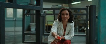 Movie still from “The One and Only Ivan” (2020), directed by Thea Sharrock – A woman sitting on the ground holding an apple; Medium shot, Over the shoulder angle