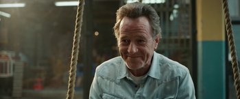 Movie still from “The One and Only Ivan” (2020), directed by Thea Sharrock – An older man smiling for the camera; Close Up shot, Over the shoulder angle