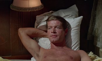 Movie still from “The Oscar” (1966), directed by Russell Rouse – A man laying in a bed with his hand behind his head; Close Up shot, High angle