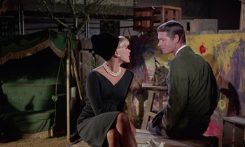 Movie still from “The Oscar” (1966), directed by Russell Rouse – A man and a woman sitting in a room; Medium shot, Low angle