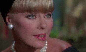 Movie still from “The Oscar” (1966), directed by Russell Rouse – A person wearing a pearl necklace; Close Up shot, Over the shoulder angle