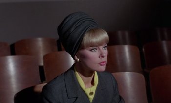 Movie still from “The Oscar” (1966), directed by Russell Rouse – A woman wearing a hat sitting in a chair; Close Up shot, Low angle