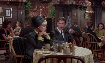 Movie still from “The Oscar” (1966), directed by Russell Rouse – A man and a woman sitting at a table in a restaurant; Medium shot, Over the shoulder angle