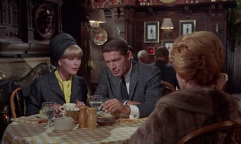Movie still from “The Oscar” (1966), directed by Russell Rouse – A group of people sitting around a table; Medium shot, Over the shoulder angle