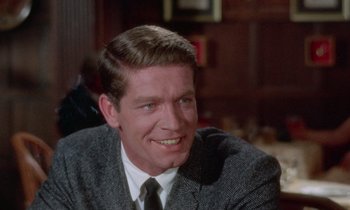 Movie still from “The Oscar” (1966), directed by Russell Rouse – A person wearing a suit and tie; Close Up shot, Over the shoulder angle