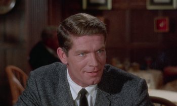 Movie still from “The Oscar” (1966), directed by Russell Rouse – A person wearing a suit and tie; Close Up shot, Over the shoulder angle