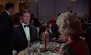 Movie still from “The Oscar” (1966), directed by Russell Rouse – A man in a tuxedo sitting at a dinner table; Medium shot, Over the shoulder angle