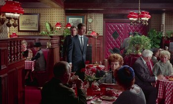 Movie still from “The Oscar” (1966), directed by Russell Rouse – A group of people sitting at a table in a restaurant; Wide shot, High angle