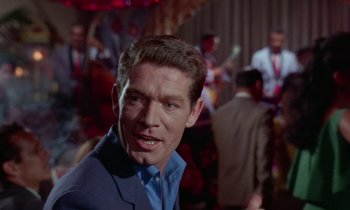 Movie still from “The Oscar” (1966), directed by Russell Rouse – A person wearing a suit and tie; Close Up shot, Over the shoulder angle