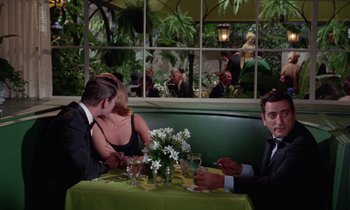 Movie still from “The Oscar” (1966), directed by Russell Rouse – A group of people sitting at a table in front of a window; Medium shot, Over the shoulder angle