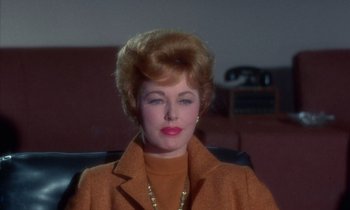 Movie still from “The Oscar” (1966), directed by Russell Rouse – An older woman wearing an orange coat and a necklace; Close Up shot, Low angle
