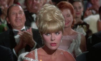 Movie still from “The Oscar” (1966), directed by Russell Rouse – A person wearing a dress; Close Up shot, Over the shoulder angle