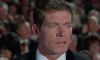 Movie still from “The Oscar” (1966), directed by Russell Rouse – A person wearing a suit and tie; Close Up shot, Over the shoulder angle