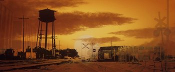 Movie still from “The Outsiders” (1983), directed by Francis Ford Coppola – An image of a train crossing in the middle of the day; Extreme Wide shot, Low angle