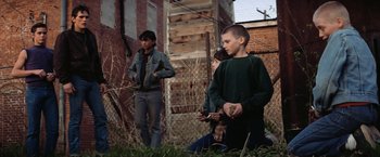Movie still from “The Outsiders” (1983), directed by Francis Ford Coppola – A group of young people standing in the grass; Wide shot, Low angle